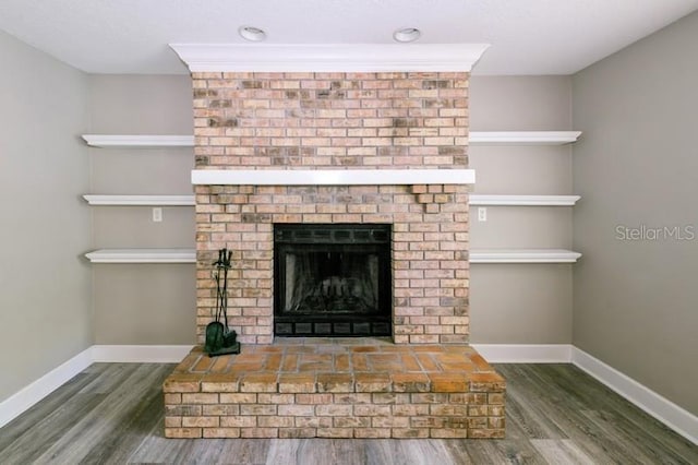 interior details featuring a fireplace, baseboards, and wood finished floors