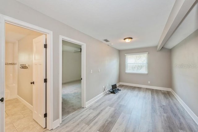 empty room with light wood finished floors, baseboards, and visible vents