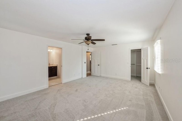 unfurnished bedroom featuring carpet floors, a closet, ensuite bathroom, a ceiling fan, and baseboards