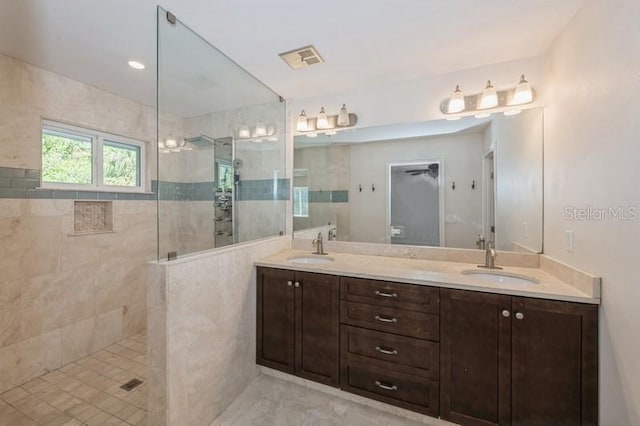 full bath featuring double vanity, walk in shower, a sink, and visible vents