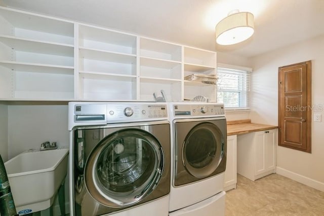 laundry area featuring laundry area, separate washer and dryer, a sink, and baseboards