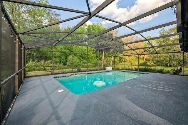 outdoor pool with glass enclosure and a patio