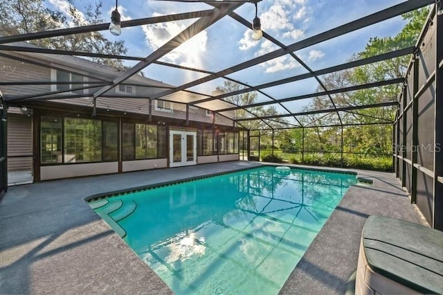 pool with glass enclosure, french doors, and a patio area