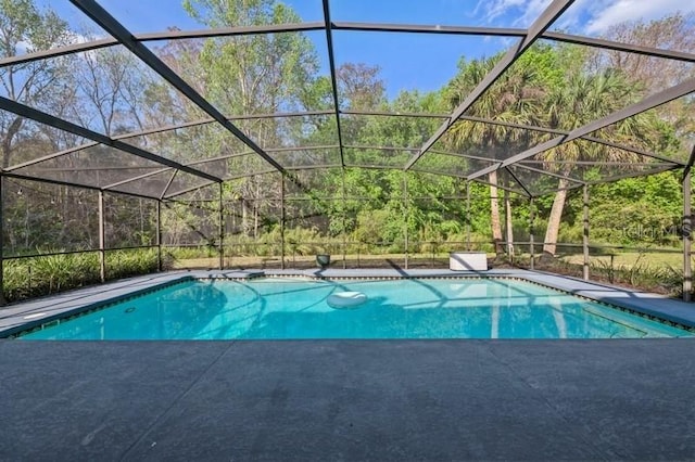 outdoor pool featuring glass enclosure and a patio area