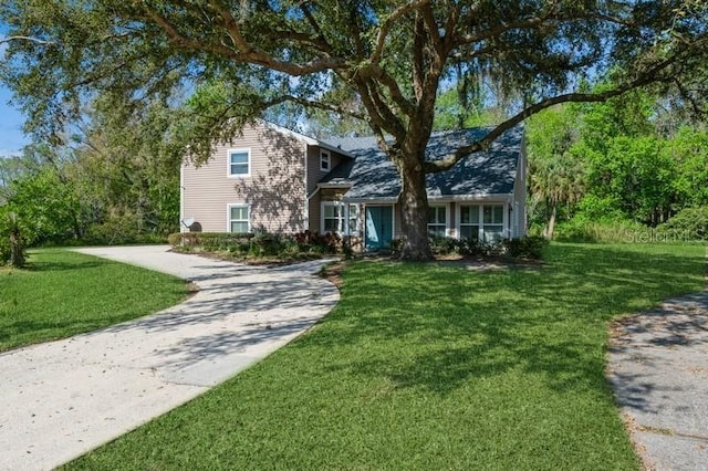 view of front of home featuring concrete driveway and a front yard