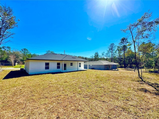 back of property featuring a yard