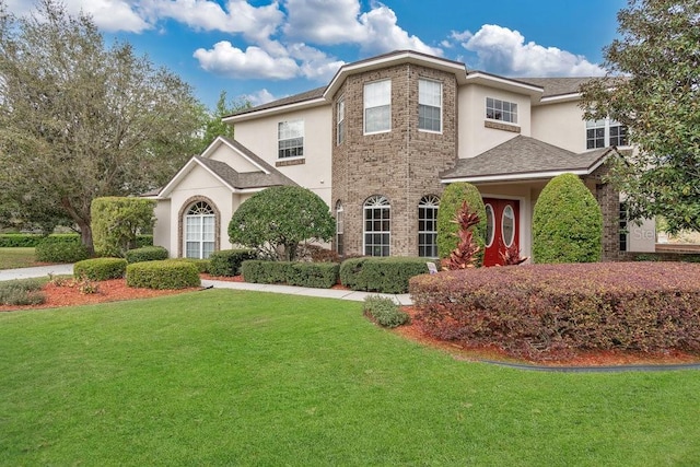 view of front of house with stucco siding and a front yard