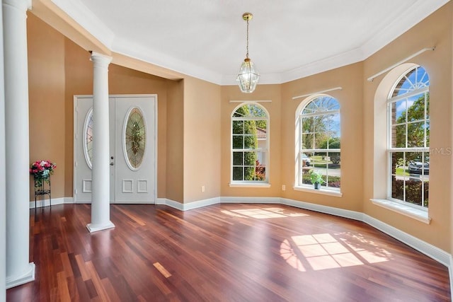 foyer with baseboards, a healthy amount of sunlight, wood finished floors, and ornate columns