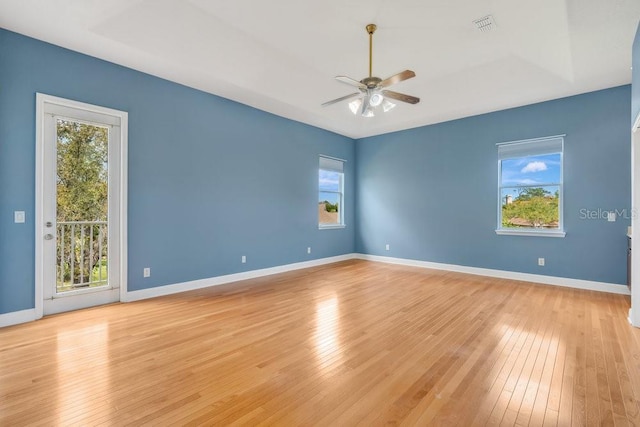 empty room with ceiling fan, baseboards, and light wood-style floors