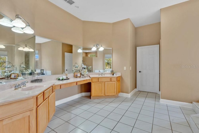 full bath featuring a sink, baseboards, two vanities, and tile patterned floors