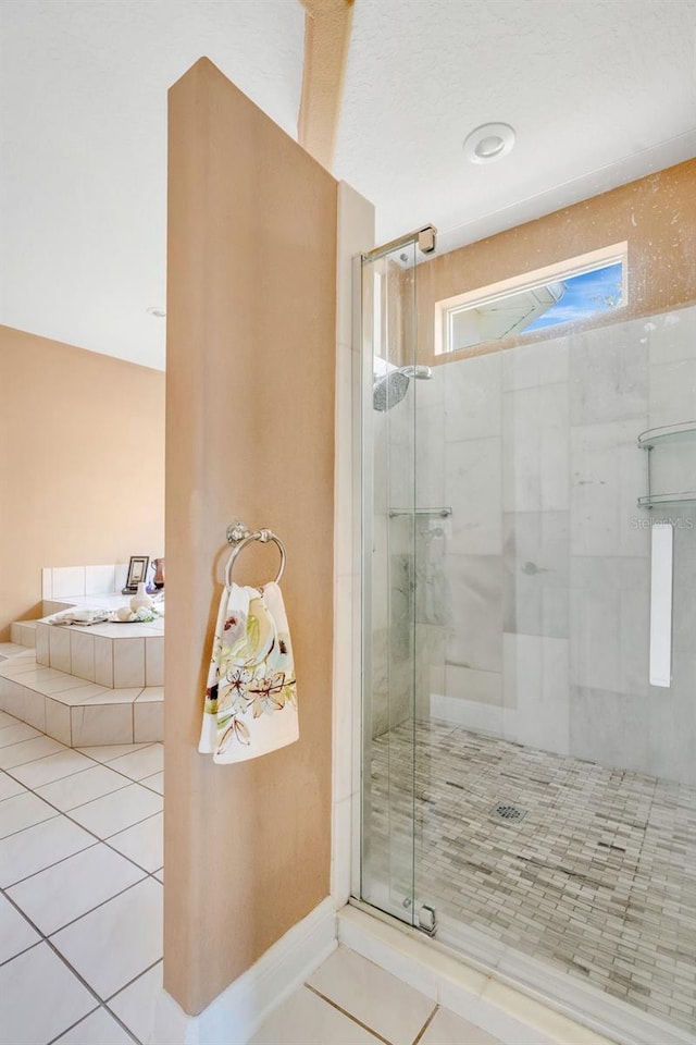 full bathroom with tile patterned floors and a shower stall