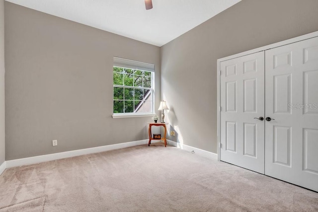 unfurnished bedroom with a closet, a ceiling fan, baseboards, and carpet floors