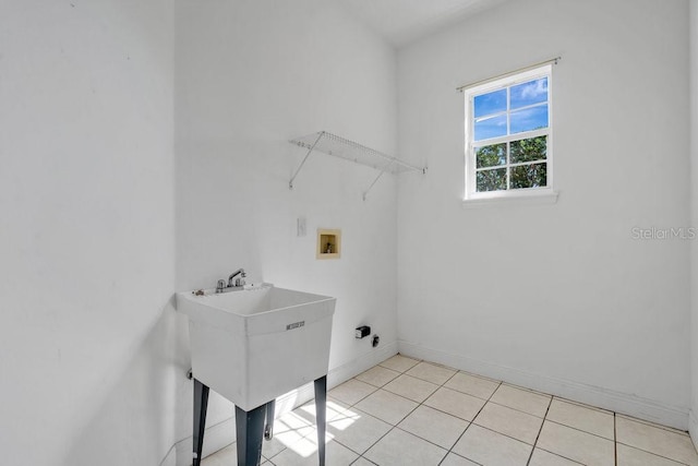 laundry area featuring laundry area, hookup for a washing machine, light tile patterned flooring, and baseboards