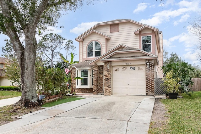 traditional-style house featuring concrete driveway, brick siding, and an attached garage