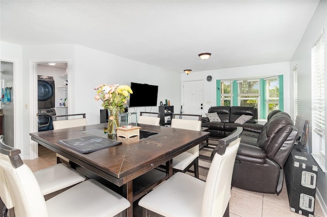 dining space with light tile patterned floors and stacked washer / dryer