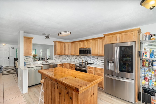 kitchen with tasteful backsplash, visible vents, a kitchen island, butcher block countertops, and appliances with stainless steel finishes