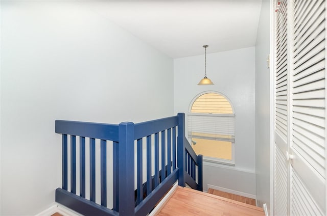 staircase with baseboards and wood finished floors