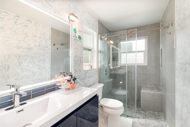 full bathroom featuring a stall shower, vanity, toilet, and wallpapered walls