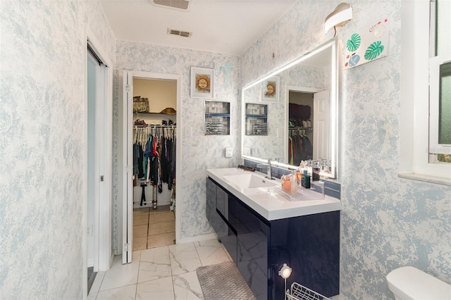 bathroom with marble finish floor, visible vents, toilet, vanity, and wallpapered walls