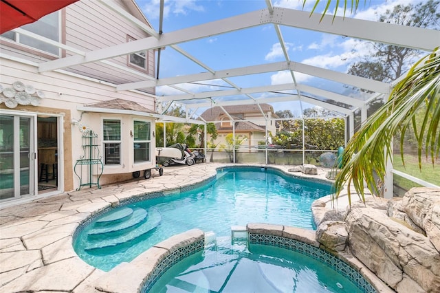 view of swimming pool with glass enclosure, a pool with connected hot tub, and a patio area