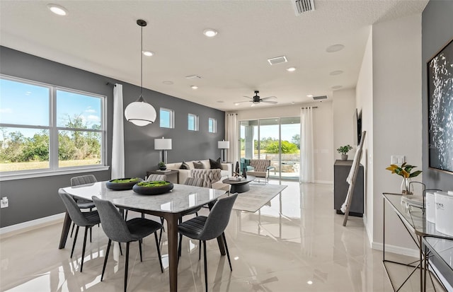 dining room with ceiling fan and a textured ceiling