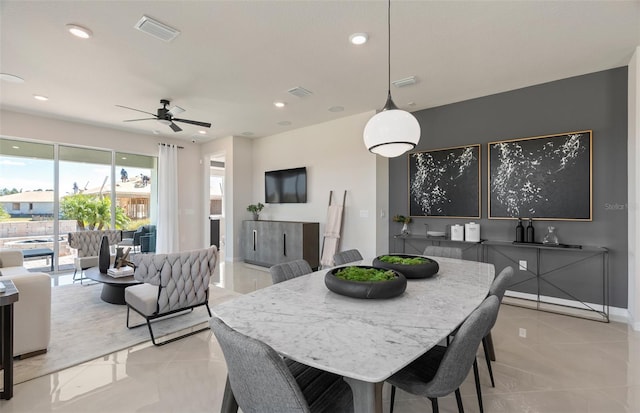 tiled dining space with ceiling fan