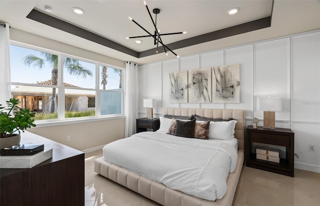 tiled bedroom featuring a notable chandelier and a tray ceiling