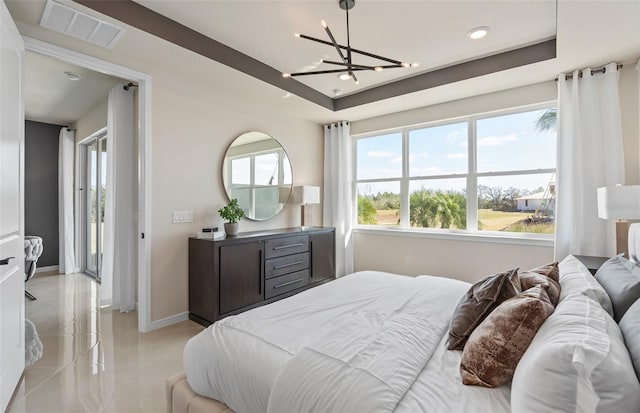 bedroom featuring a tray ceiling and a chandelier