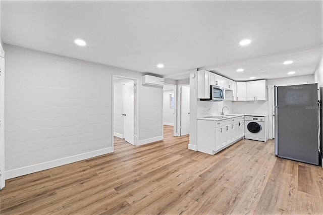 kitchen featuring washer / dryer, stainless steel appliances, white cabinetry, and light countertops