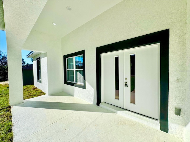 property entrance featuring french doors and a patio area