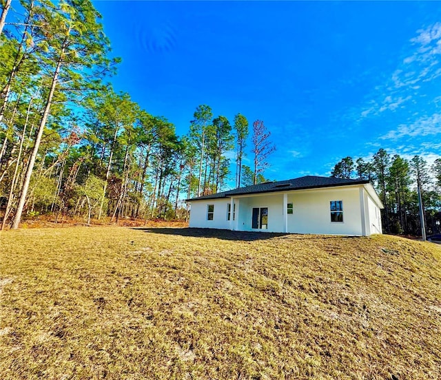 rear view of property featuring a yard