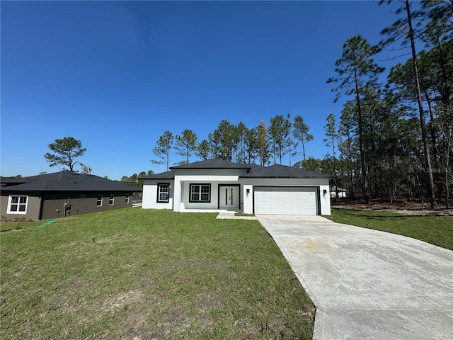 prairie-style house with a garage, stucco siding, driveway, and a front yard