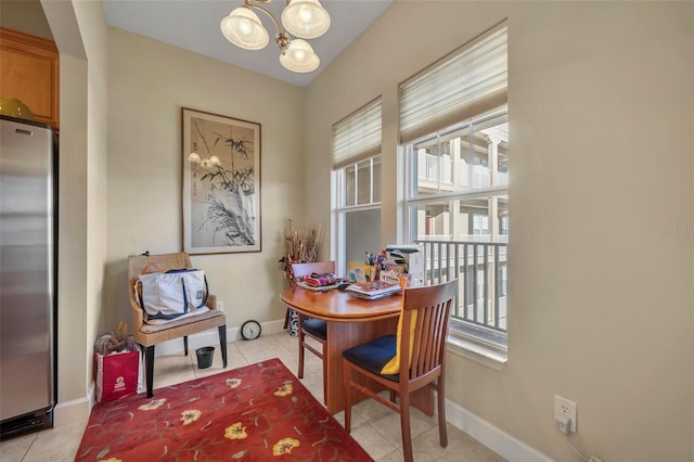 tiled dining space featuring a notable chandelier and plenty of natural light