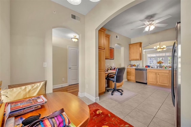 tiled home office with ceiling fan with notable chandelier