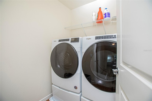 laundry room featuring laundry area, baseboards, and washing machine and clothes dryer