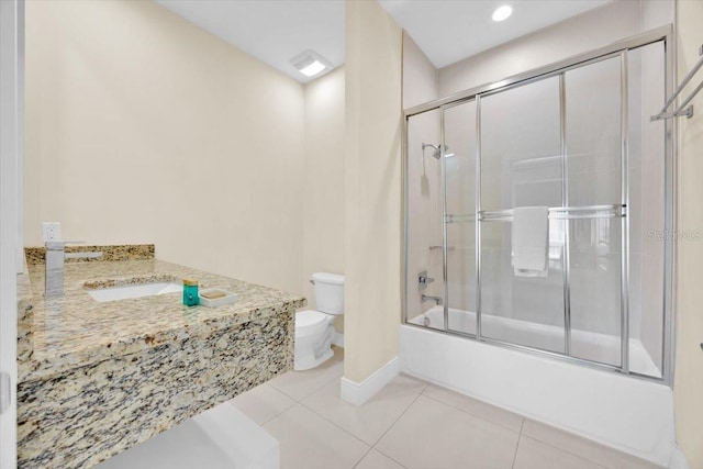 bathroom with shower / bath combination with glass door, toilet, vanity, baseboards, and tile patterned floors