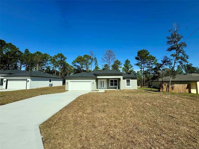 single story home with driveway, stucco siding, an attached garage, and a front yard