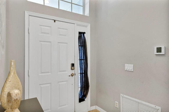 foyer entrance with visible vents and baseboards