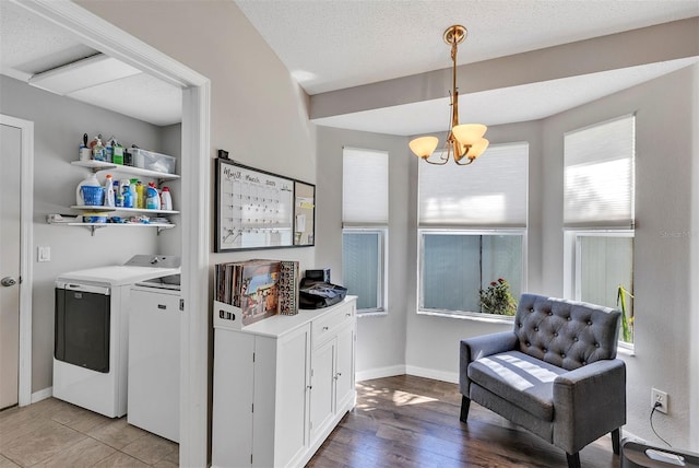 washroom with a textured ceiling, laundry area, washer and clothes dryer, and baseboards