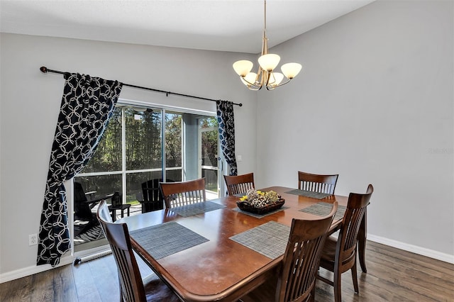 dining space featuring lofted ceiling, a notable chandelier, baseboards, and wood finished floors