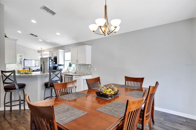 dining room with dark wood-style floors, visible vents, and an inviting chandelier