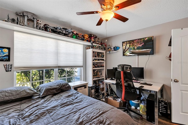 bedroom featuring a textured ceiling, wood finished floors, and a ceiling fan