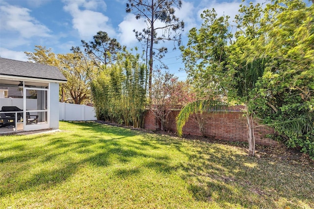 view of yard featuring a fenced backyard and a sunroom