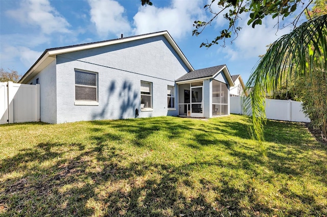 back of property with a sunroom, a fenced backyard, a lawn, and stucco siding