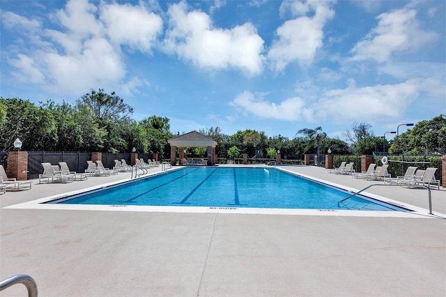 community pool featuring a patio area, fence, and a gazebo