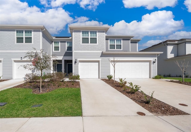 multi unit property with a garage and a front yard