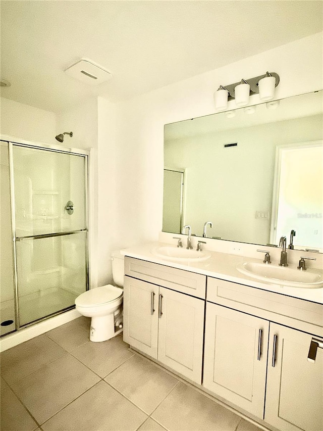 full bathroom with tile patterned flooring, a sink, a shower stall, and double vanity