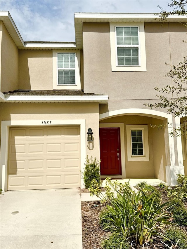 view of front of property with driveway, a garage, and stucco siding