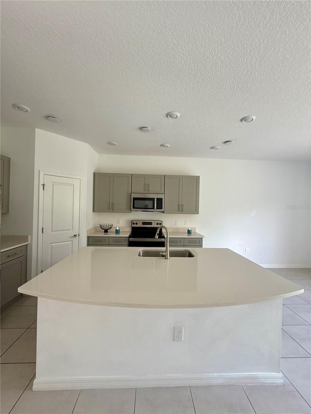 kitchen featuring light countertops, a sink, and a large island