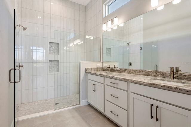 bathroom with tile patterned floors, vanity, and a shower with door